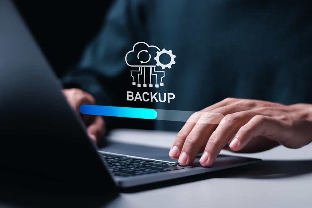 BackupConceptPersonUseLaptopWithVirtualBackupStatusBar Data Backup & Disaster Recovery Strategies for Resilience