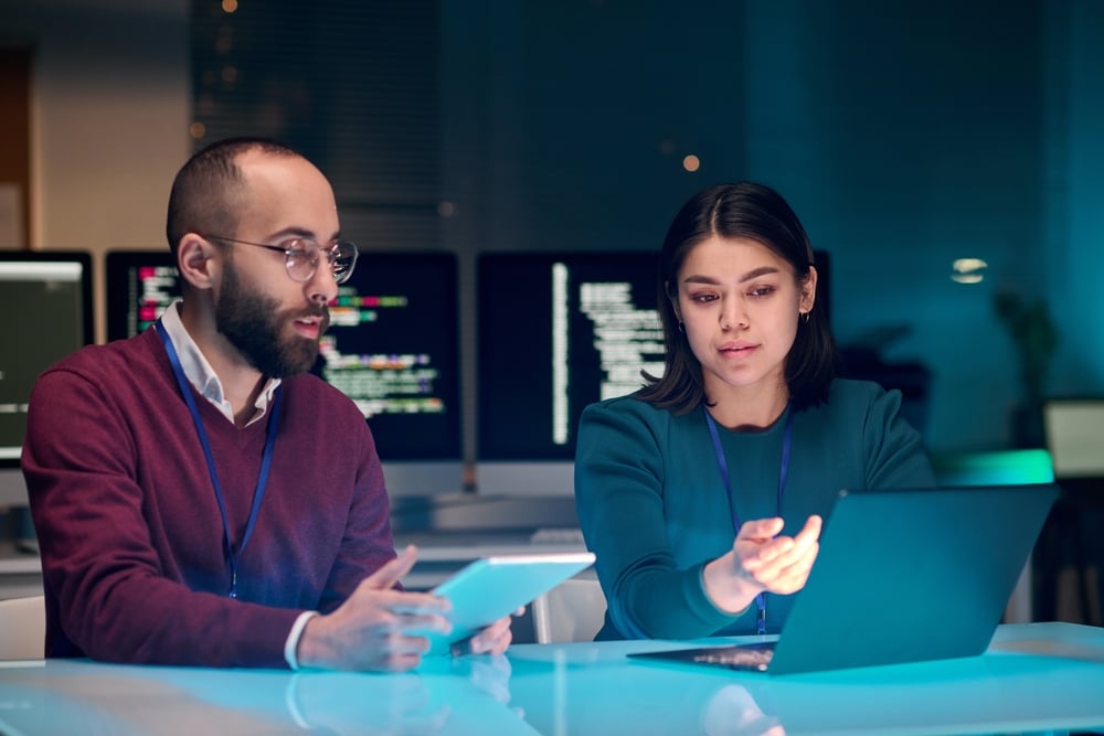 Portraitofyoungwomanasfemaleitsecurityexpertusing | enstep technology solutions a Man and a Woman Discussing It Support Infront of a Laptop