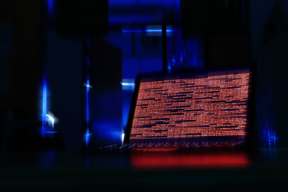ComputerLaptopInADarkRoomComputerDisplayingRedCode