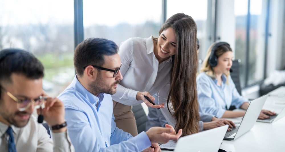 BusinesswomanProvidingSupervisionToCallCenterEmployeesInAnOffice Businesswoman providing supervision to call center employees in an office.