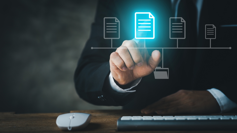 BusinessmanWearingFormalSuitsPointingToHologramsOfDigitalDocument Businessman wearing formal suits pointing to holograms of digital document files, data files on computers stored as cloud database