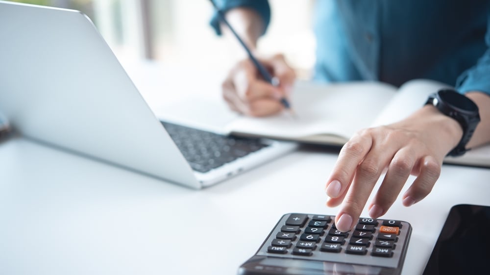 Close,Up,Business,Woman,Working,,Using,Calculator,To,Calculate,Home