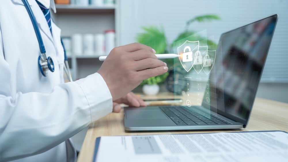 DoctorUsingLaptopWithDigitalSecurityLockIconsRepresentingPatient